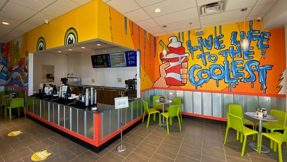 Photo of interior of Jeremiah’s Italian Ice business with orange walls and green chairs