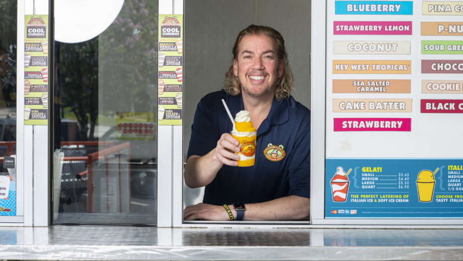Image of man smiling and holding a cup of ice cream